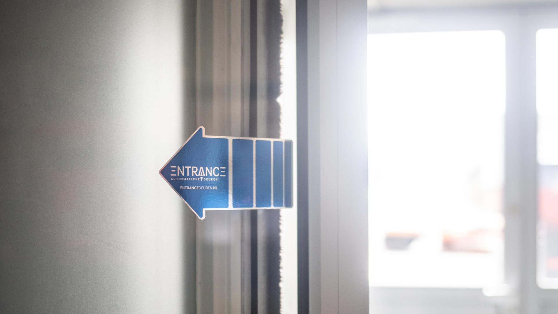 Pijltje naar links met de tekst "ENTRANCE" op een deur.