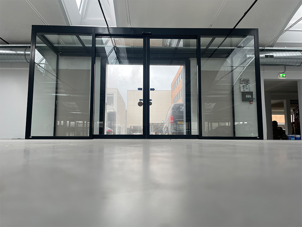 Glazen schuifdeuren met metalen frame, zichtbaar in een lichte ruimte.